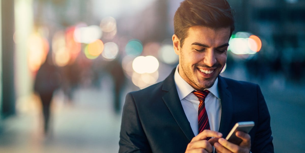 hombre profesional usando celular, parada afuera, ciudad