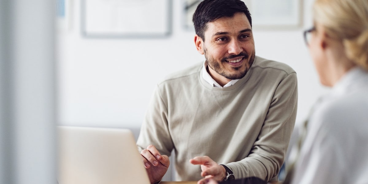 man in office, speaking to colleague