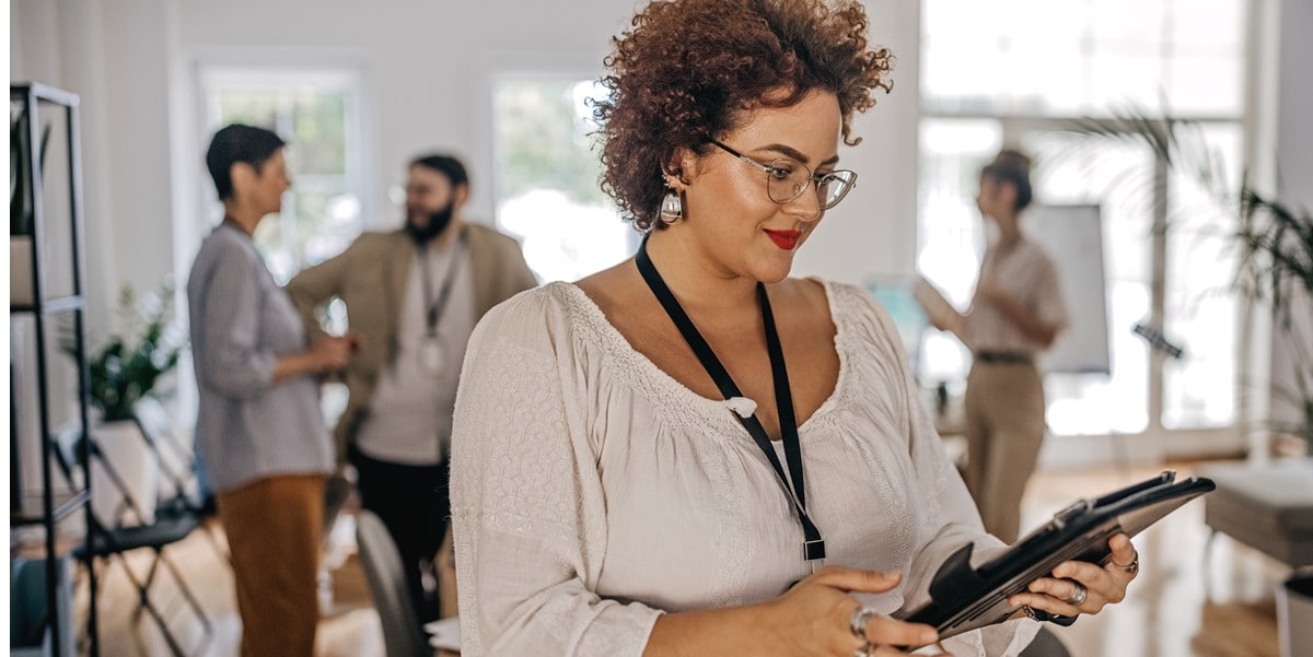 woman in office, looking at tablet in her hands