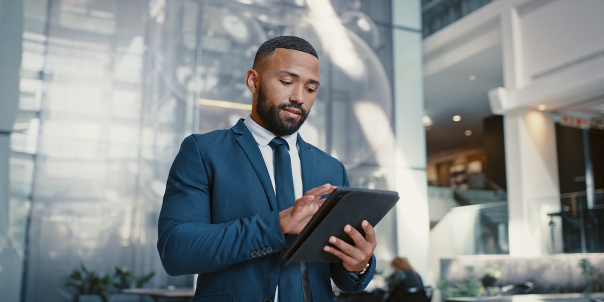 professional man in office building, looking at tablet