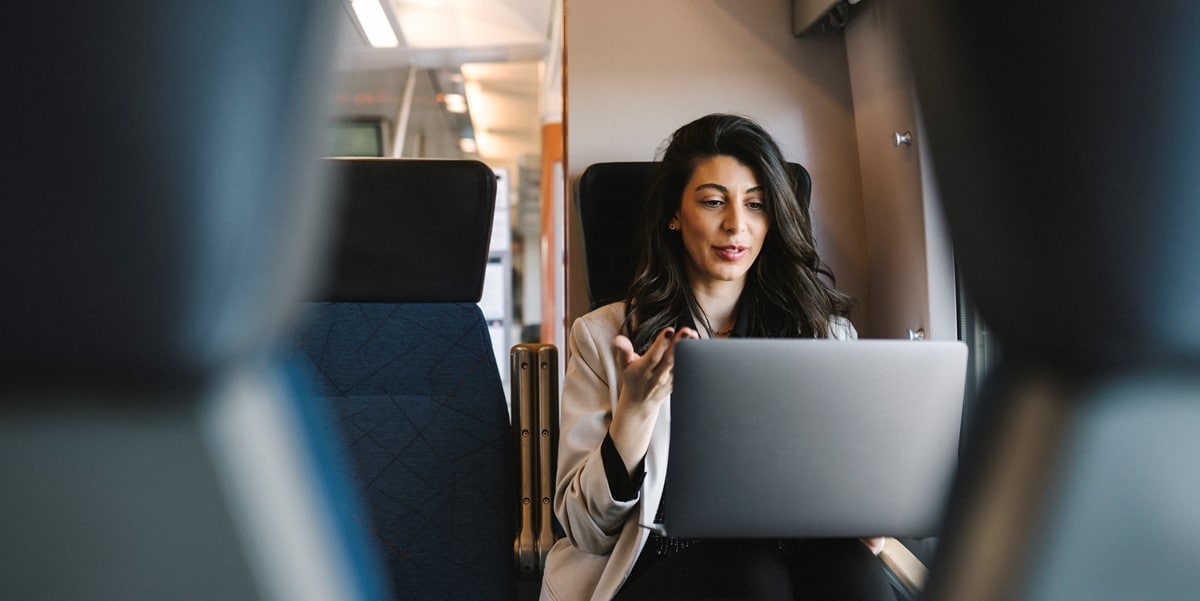 woman travelling by train, working on laptop